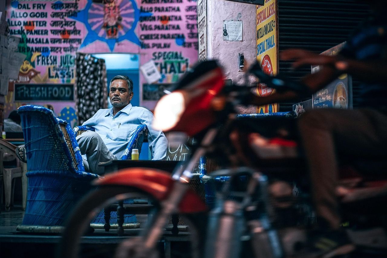 business, businessman, closing, couch, display, indian, male, man, market, metal, metallic, motor, motorcycle, rider, owner, person, seller, shop, shop owner, s